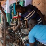 A mechanic working on a motorcycle in Eastern Cameroon, highlighting vocational skills training programs.