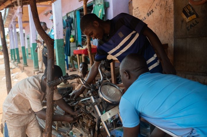 A mechanic working on a motorcycle in Eastern Cameroon, highlighting vocational skills training programs.