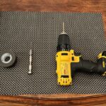 Tools for modifying a model train tank car's sound, including paint stick, tape, pin vise, and drill.