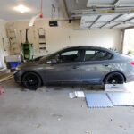 Toe plates being used to measure wheel alignment, a DIY approach for car enthusiasts.