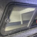 Side window of a vehicle, indicating the area for a DIY car fan installation, highlighting the crank handle that needs to be worked around.