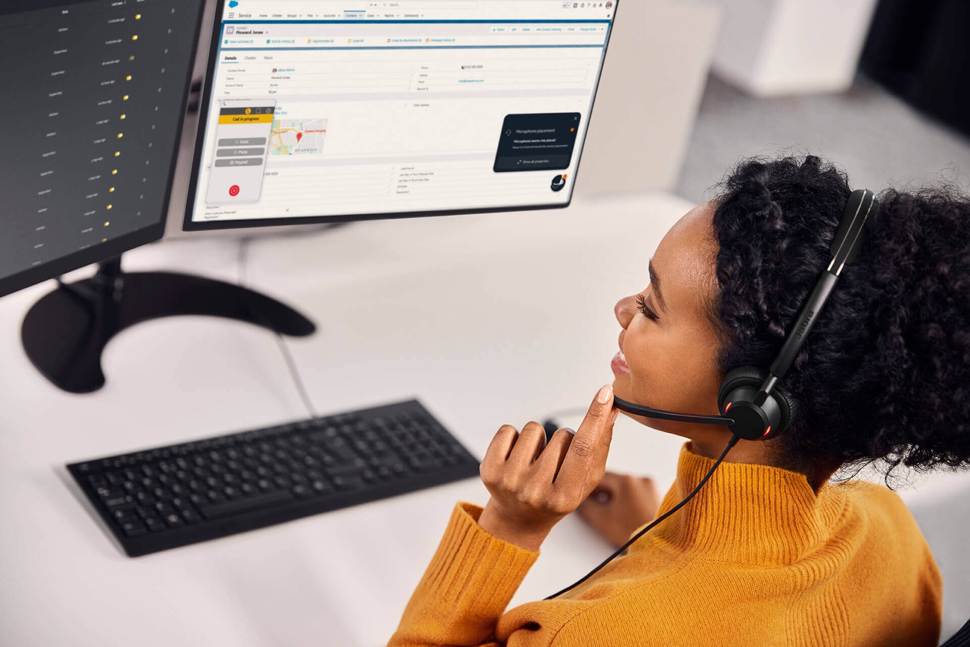 Female office worker using Jabra Engage 50 II headset, adjusting boom arm, representing voice in customer care.