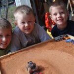 Three boys playing with matchbox cars