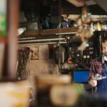 Professional mechanic inspecting car engine with tool