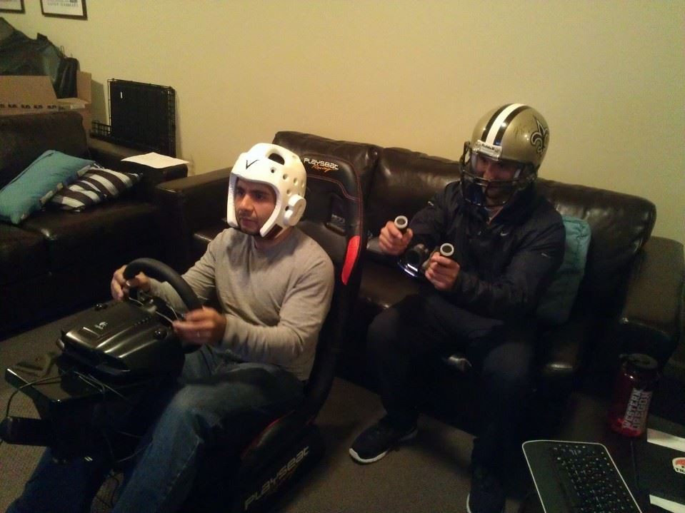 alt text: Two people playing a racing simulator game