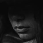 A woman looking contemplative while sitting on a couch.