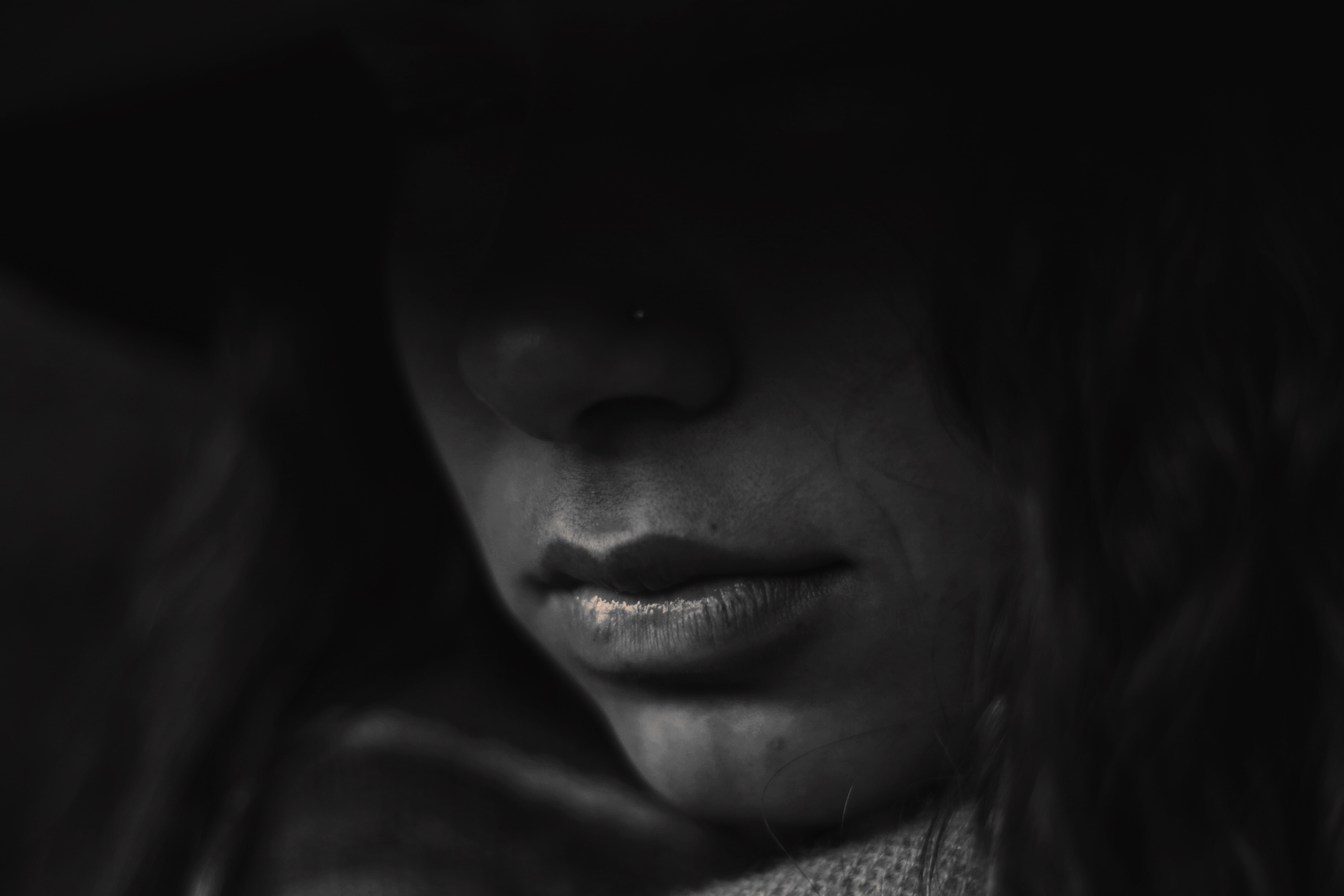 A woman looking contemplative while sitting on a couch.